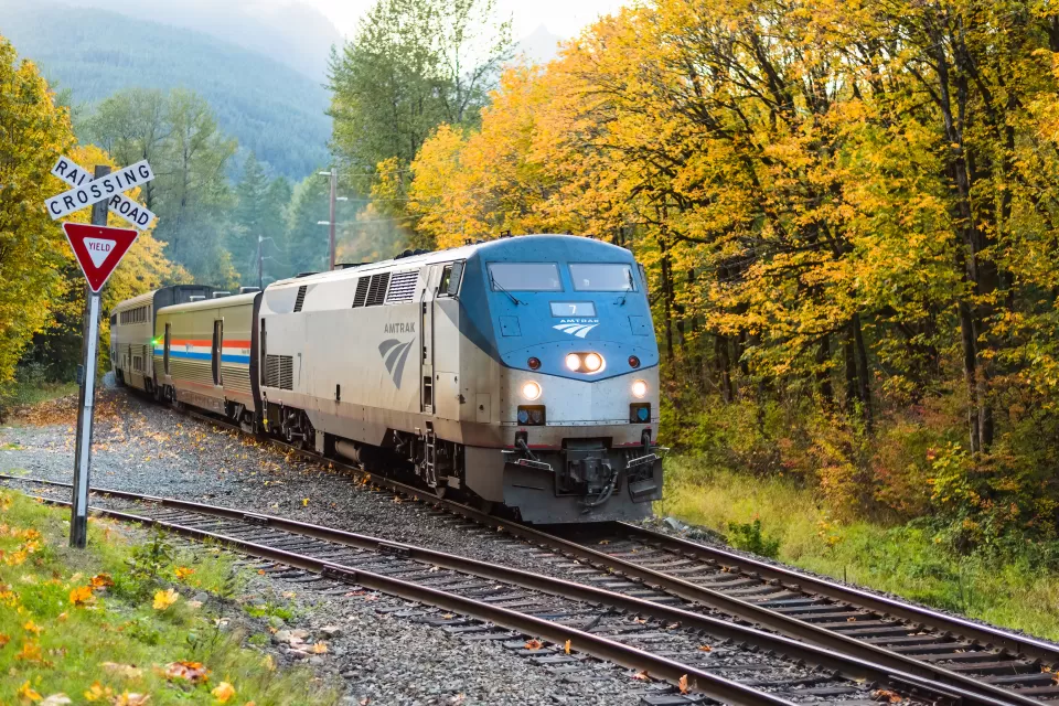 An eastbound Amtrak Empire Builder passes through the Cascade Mountains as the trees turn fall colors in Skykomish, WA